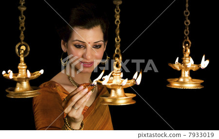 Woman lighting diyas 7933019