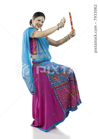Gujarati woman dancing with dandiya sticks 7933062