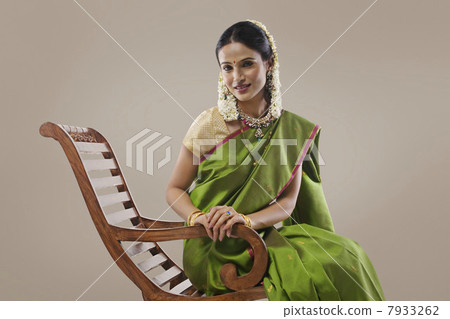 South Indian woman sitting on an arm chair South Indian woman sitting on an arm chair 7933262