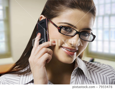 Portrait of a secretary talking on a mobile phone Portrait of a secretary talking on a mobile phone 7933478