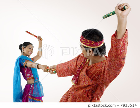 Gujarati couple performing dandiya Gujarati couple performing dandiya 7933514