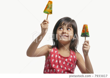 Little girl holding two ice lollies 7933817