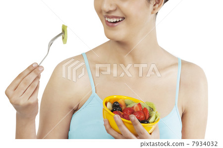 Woman eating fruits from a bowl 7934032