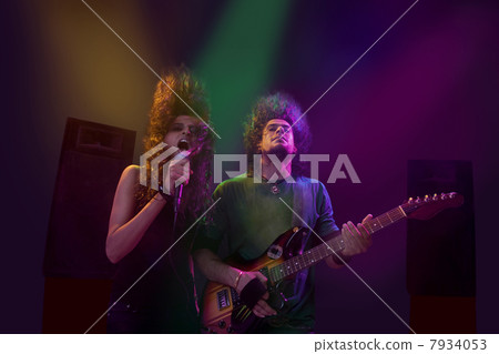 Woman singing while man plays on the guitar Woman singing while man plays on the guitar 7934053