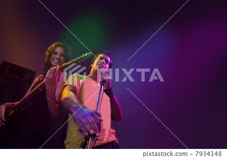 Man singing while a woman plays the guitar 7934148