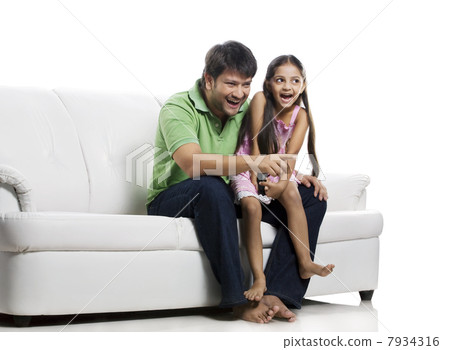 Father and daughter watching television Father and daughter watching television 7934316