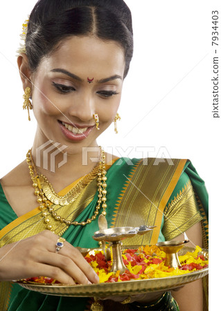 Woman holding a tray with diyas 7934403