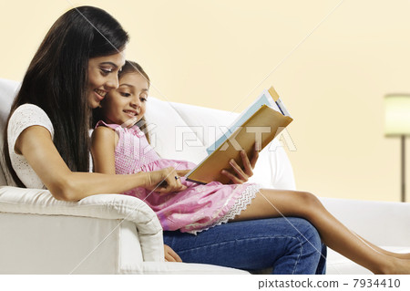 Mother and daughter reading a story book Mother and daughter reading a story book 7934410