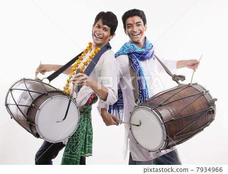 Two men playing on dholaks 7934966