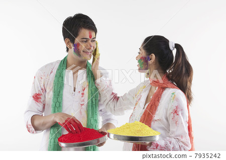 Woman putting colour on a mans face Woman putting colour on a mans face 7935242