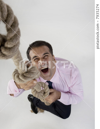 Businessman trying to climb a rope Businessman trying to climb a rope 7935274