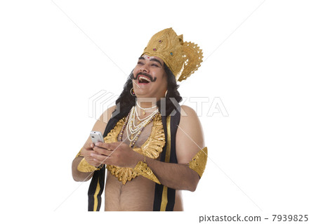 Man dressed as Raavan with a mobile phone laughing Man dressed as Raavan with a mobile phone laughing 7939825