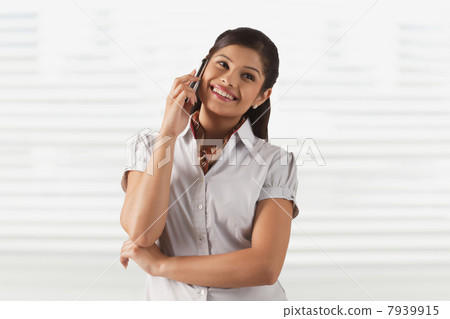 Pretty young business woman smiling while attending phone call 7939915