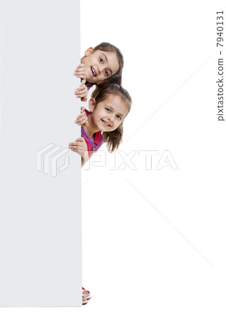 Girls peeking through blank billboard Girls peeking through blank billboard 7940131