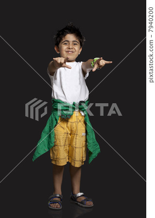 Portrait of boy gesturing over black background Portrait of boy gesturing over black background 7940200