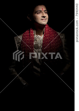 Handsome young groom in sherwani smiling 7940440