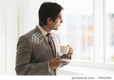 Smart young businessman taking coffee break at office 7940460