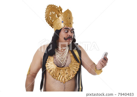 Man dressed as Raavan reading an sms Man dressed as Raavan reading an sms 7940483