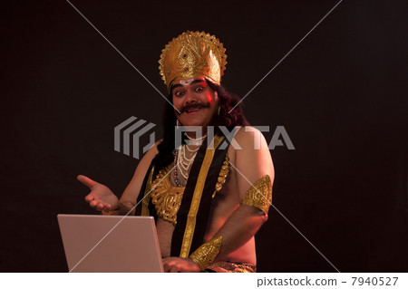 Portrait of a man dressed as Raavan with a laptop 7940527