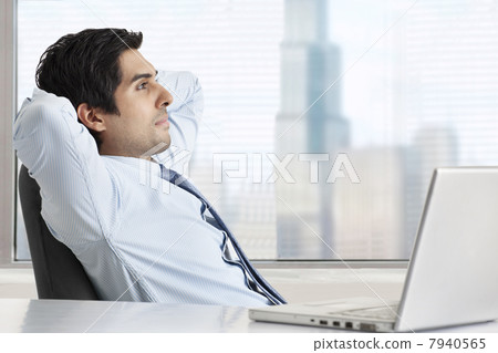 Side view of thoughtful businessman relaxing at his desk 7940565