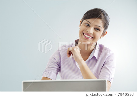 Smiling businesswoman using laptop over colored background 7940593