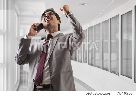 Smart young business man celebrating his success at office 7940595