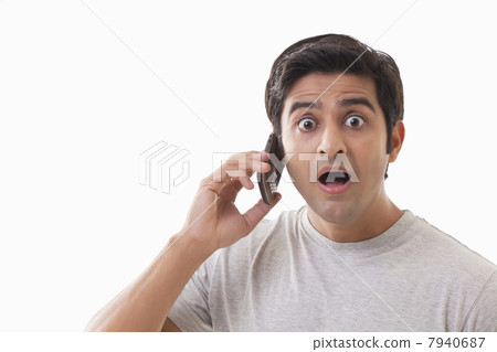 Portrait of surprised man using cell phone over white background 7940687
