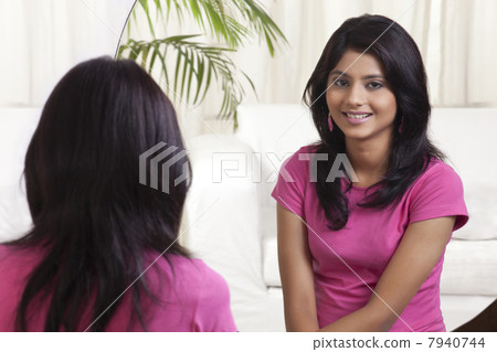 Teenage girl sitting in front of mirror 7940744