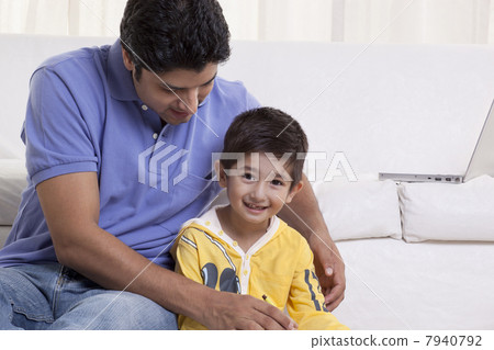 Young father assisting his son in drawing at home 7940792