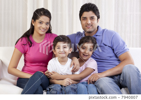 Portrait of happy family sitting on sofa 7940807