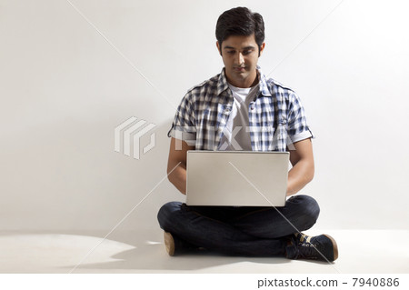 Full length of handsome man using laptop Full length of handsome man using laptop 7940886