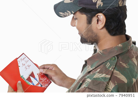 Smiling young soldier holding greeting card 7940951