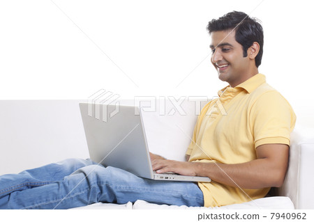 Smiling young man working on laptop 7940962