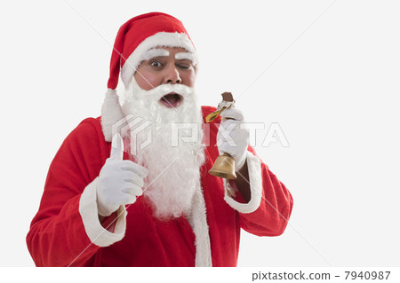 Front view of Santa Claus showing thumbs up while eating chocolate bar over white background 7940987
