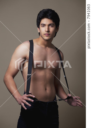 Portrait of shirtless man wearing suspenders 7941063