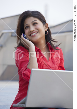 Female student talking on mobile phone in college campus 7941069