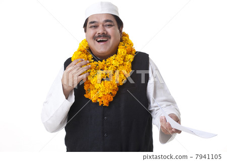 Portrait of happy politician wearing garlands 7941105