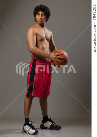 Confident basket ball player standing over grey background 7941208