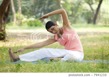 Smiling young woman doing stretching exercise 7941210