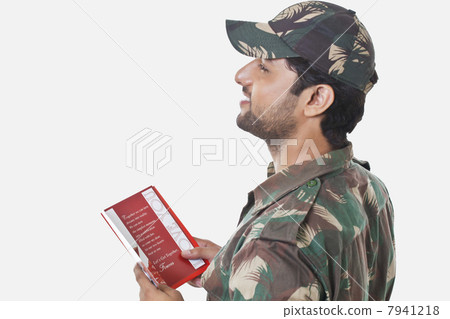 Happy soldier holding greeting card and looking away 7941218