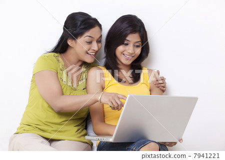 Mother and daughter using computer together over white background 7941221