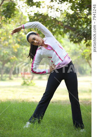 An attractive young woman exercising in park 7941248