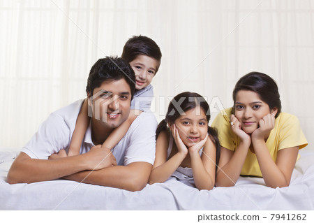 Portrait of family lying in bed 7941262