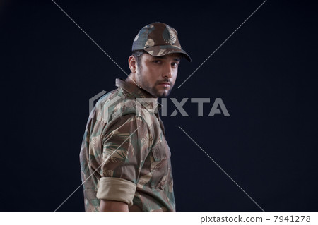 Portrait of young soldier standing over black background 7941278