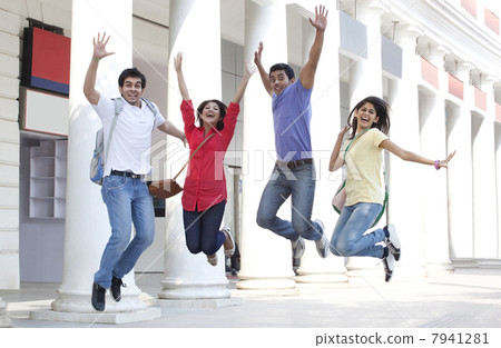 College students jumping with building in the background 7941281