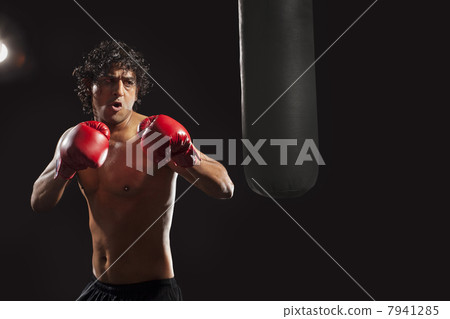 Male boxer about to hit punching bag Male boxer about to hit punching bag 7941285