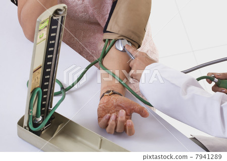 High angle view of doctor checking patients blood pressure High angle view of doctor checking patients blood pressure 7941289
