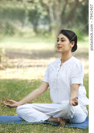 Young woman sitting in lotus position 7941407