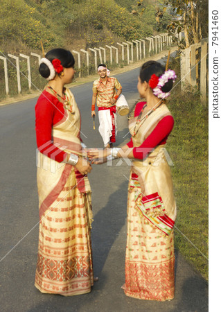 Bihu dancers look on as a Bihu man walks up to them 7941460