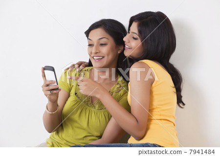 Teenage girl pointing on mobile phone 7941484
